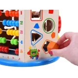 Kompaktowa kostka edukacyjna ustawiona na podłodze w otoczeniu kolorowych klocków