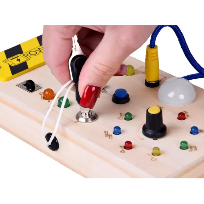 detal pokrętła i kolorowych światełek na drewnianej tablicy