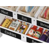 drewniane pojemniczki na warzywa przy straganie z nazwami na tabliczkach