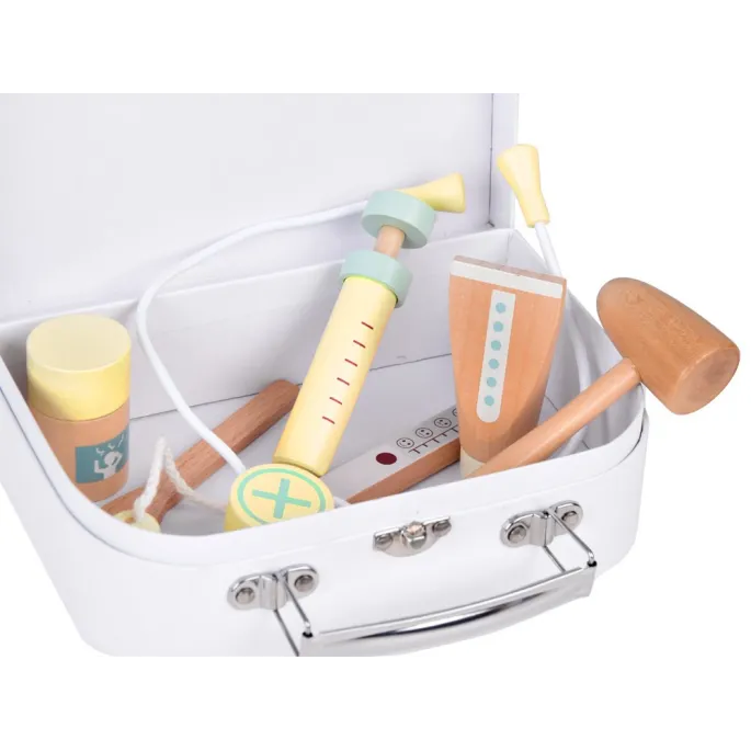 elementy zestawu lekarskiego ułożone na blacie obok walizki