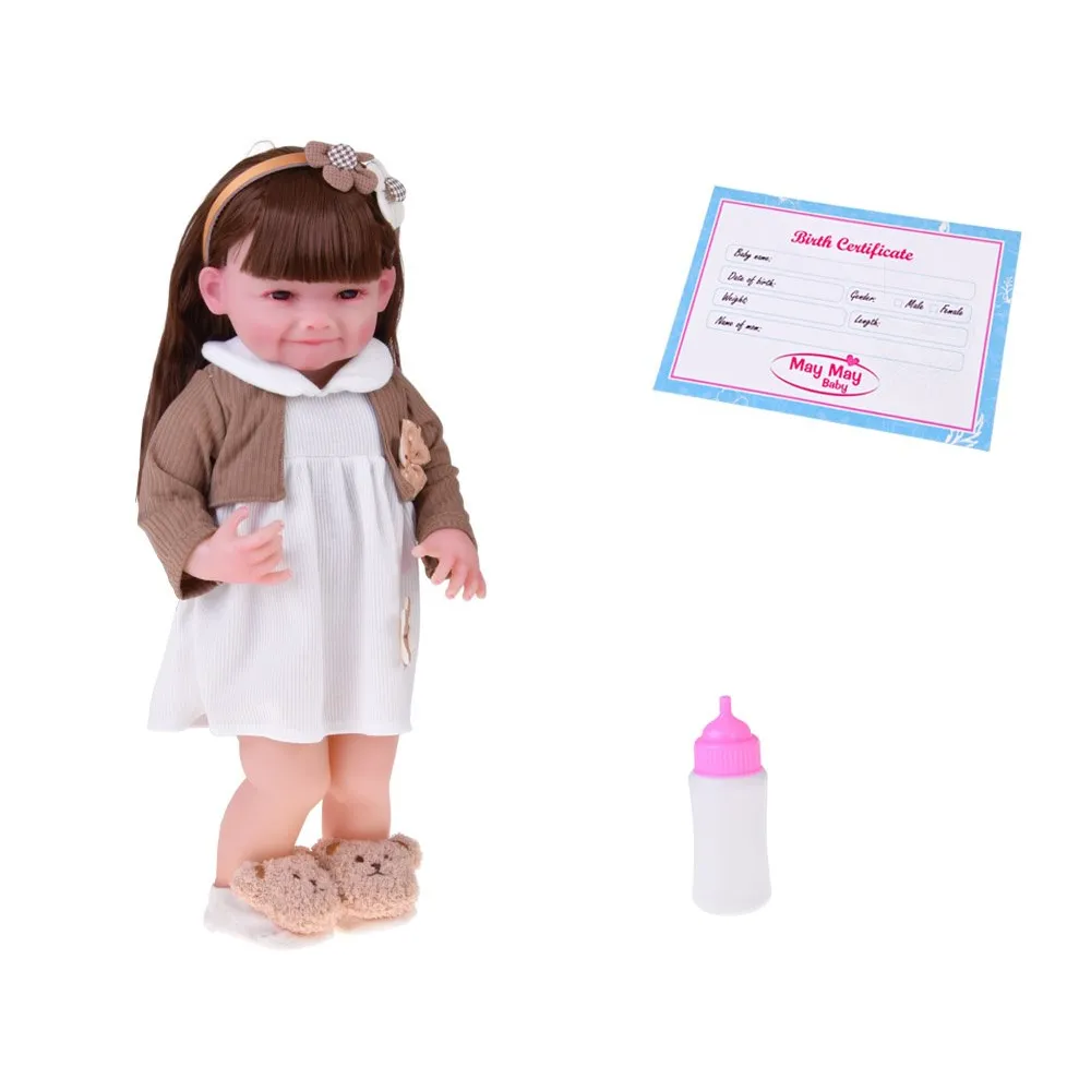 lalka w białej sukience z kwiatową aplikacją oraz brązowym sweterkiem