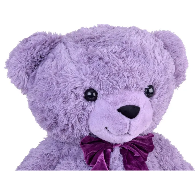 pluszowy miś benia leżący na kanapie, pokazujący miękkie futerko