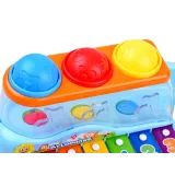 Drewniany młotek obok zestawu cymbałków z piłeczkami