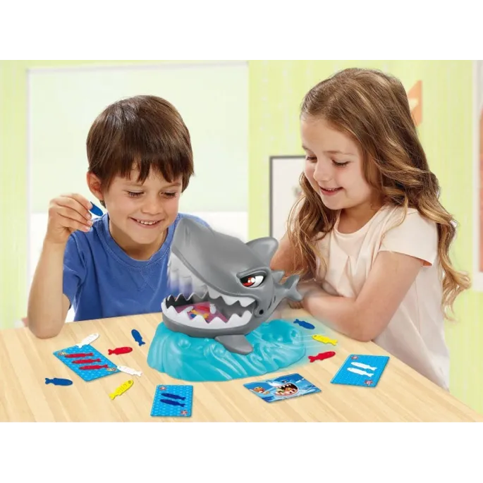 dziecko wyciąga rybkę z paszczy rekina