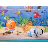 Pojemnik na karmę obok podświetlonego akwarium z rybkami