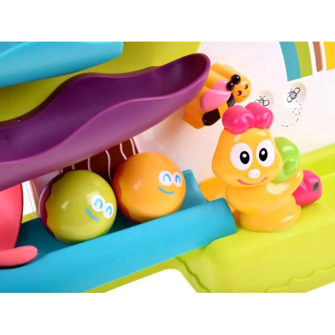 zbliżenie na mechanizm lwiątka oraz kolorowe kulki na torze