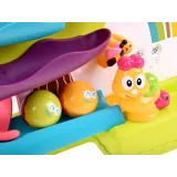 zbliżenie na mechanizm lwiątka oraz kolorowe kulki na torze