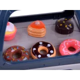 Zabawa w baristę z kubkiem oraz saszetkami cukru przy ekspresie