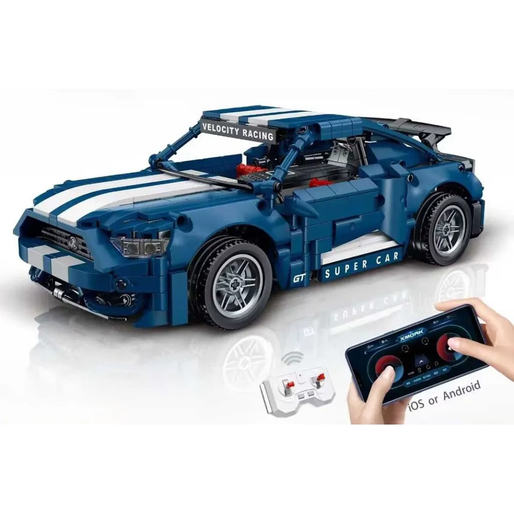 Pilot zdalnego sterowania i model niebieskiego samochodu na białym tle