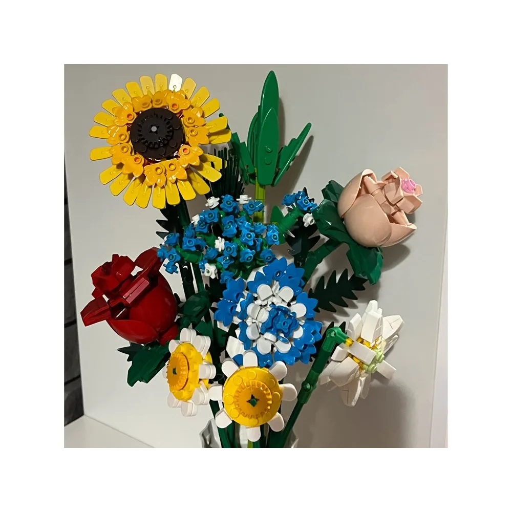 rozbudowana kompozycja kwiatowa z różnymi gatunkami kwiatów