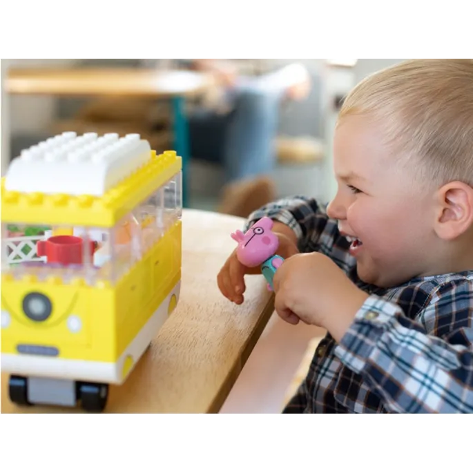 peppa i tata siedzący na ławce obok kampera z klocków