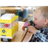 peppa i tata siedzący na ławce obok kampera z klocków