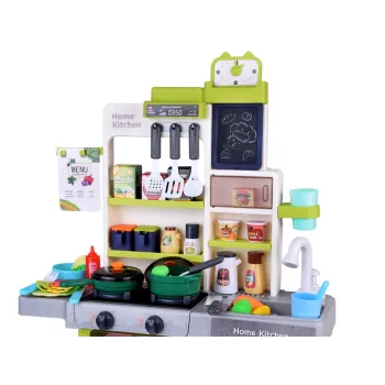 dziecko bawiące się kuchnią interaktywną i notujące przepis na tablicy