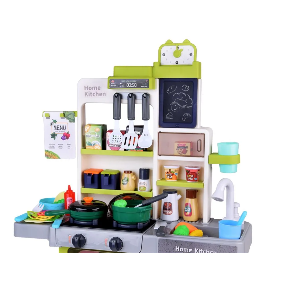 dziecko bawiące się kuchnią interaktywną i notujące przepis na tablicy