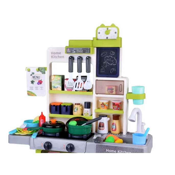 dziecko bawiące się kuchnią interaktywną i notujące przepis na tablicy