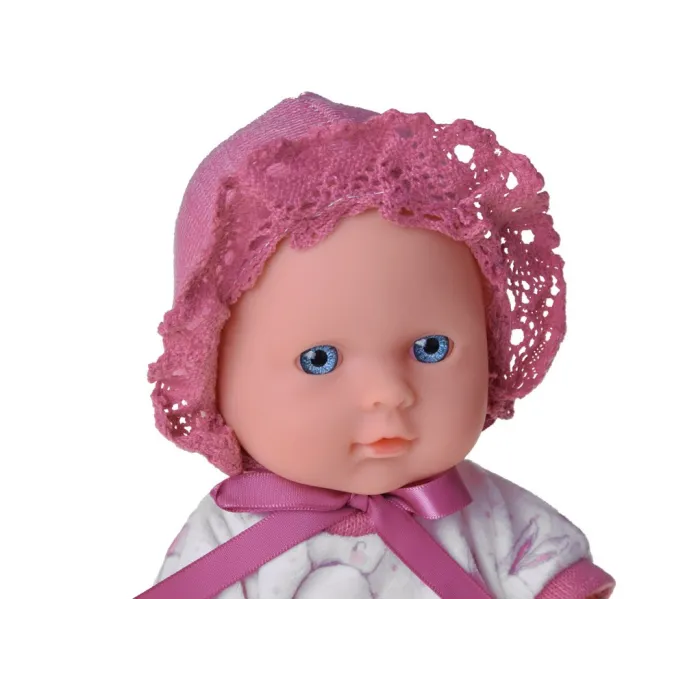 zbliżenie na detale twarzy lalki bobas z białym ubrankiem