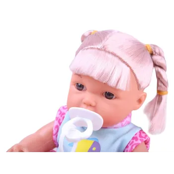 Lalka w pozycji leżącej z widocznym nosidełkiem i akcesoriami