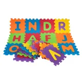 dziecko układające puzzle sensoryczne z pianki z alfabetem