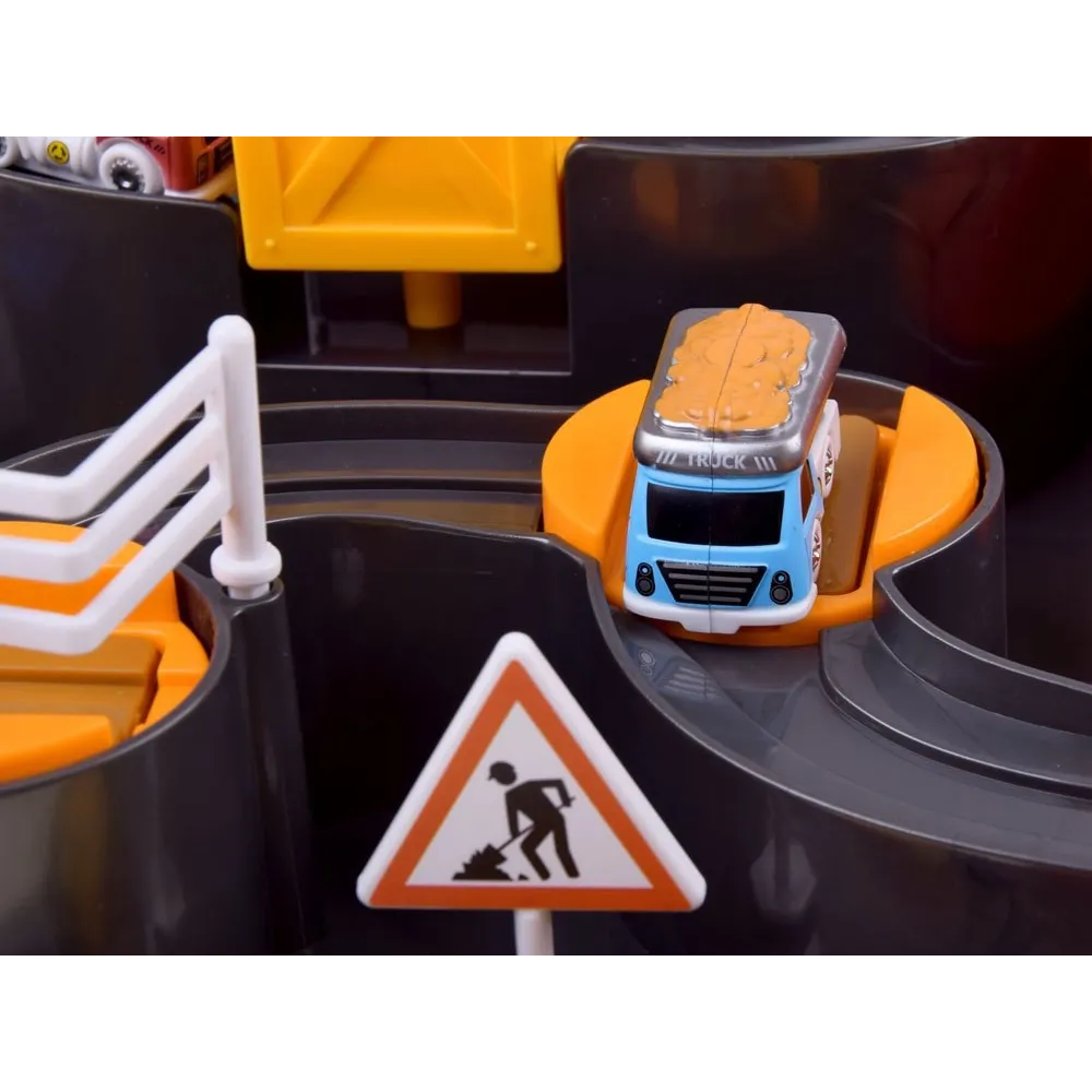 Figurka inżyniera budowy obok pojazdów na torze