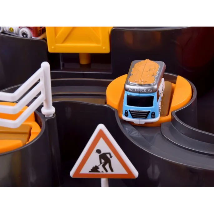 Figurka inżyniera budowy obok pojazdów na torze