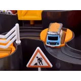 Figurka inżyniera budowy obok pojazdów na torze