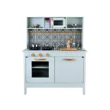 zbliżenie na złote pokrętła i czarno-białą mozaikę kuchni