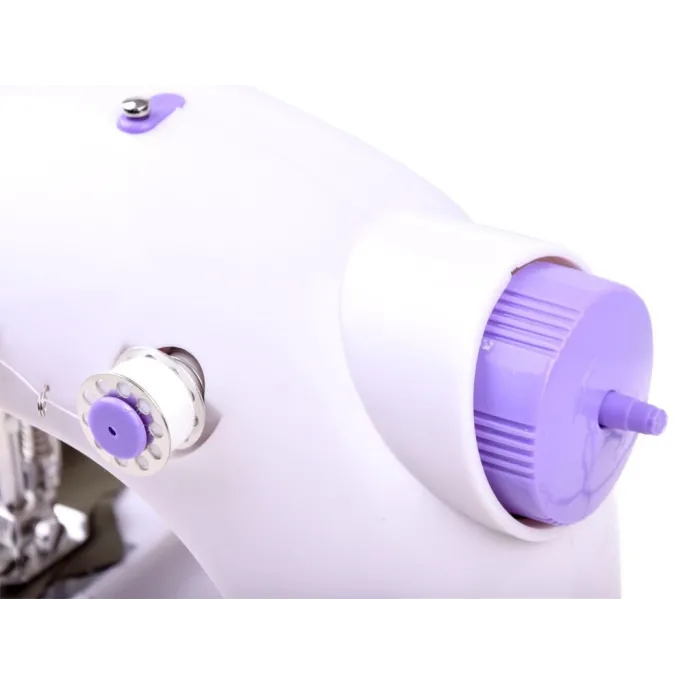 zawartość zestawu z igłą, szpulkami i nawlekaczem przy maszynie do szycia