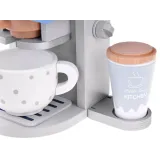 cały zestaw ekspresu, akcesoriów i opakowania na jasnym tle