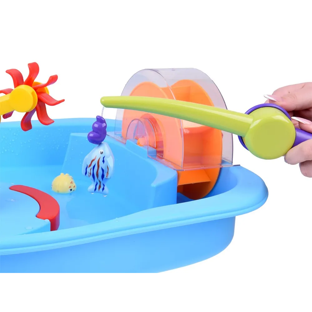 dziecko łowiące rybki plastikową wędką przy stoliku wodnym