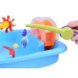 dziecko łowiące rybki plastikową wędką przy stoliku wodnym