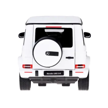 Pilot do zdalnego sterowania modelem Mercedes AMG G63 na tle samochodu