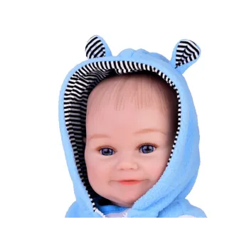 Lalka chłopiec śmieje się podczas zabawy na miękkiej powierzchni