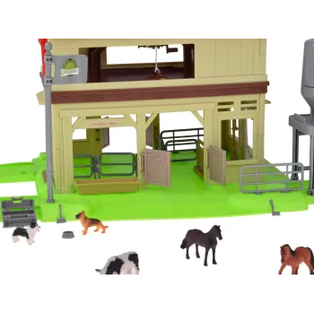 Różnorodne figurki zwierząt gospodarskich przy stogu siana