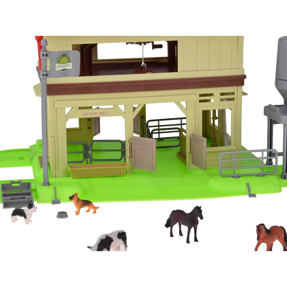 Różnorodne figurki zwierząt gospodarskich przy stogu siana