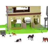 Różnorodne figurki zwierząt gospodarskich przy stogu siana