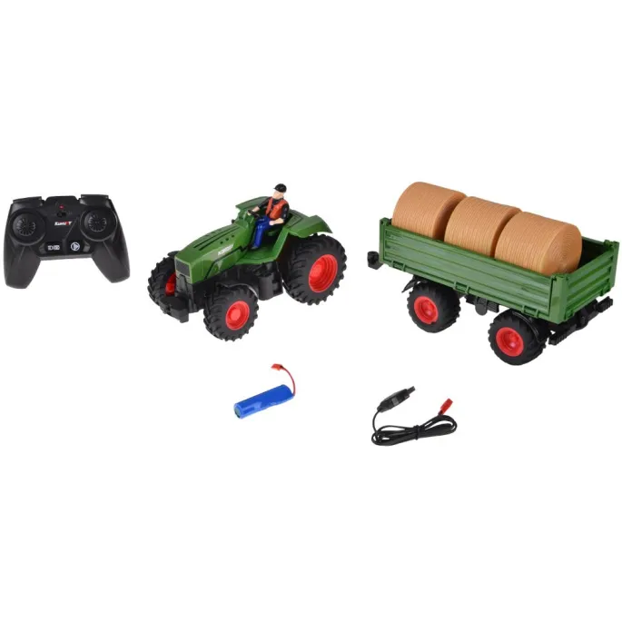 Figurka traktorzysty obok zielonego traktora z gumowymi oponami