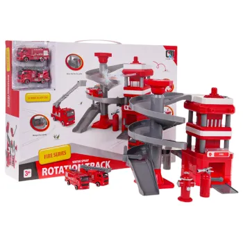 Oba samochodziki strażackie z metalową karoserią stojące obok remizy