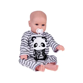 Lalka chłopiec siedząca w kombinezonie panda na tle jasnym