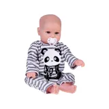 Lalka chłopiec siedząca w kombinezonie panda na tle jasnym