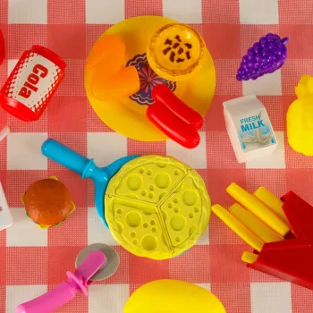 Zbliżenie na dziecięcy talerzyk z zabawkowym jedzeniem i naklejkami