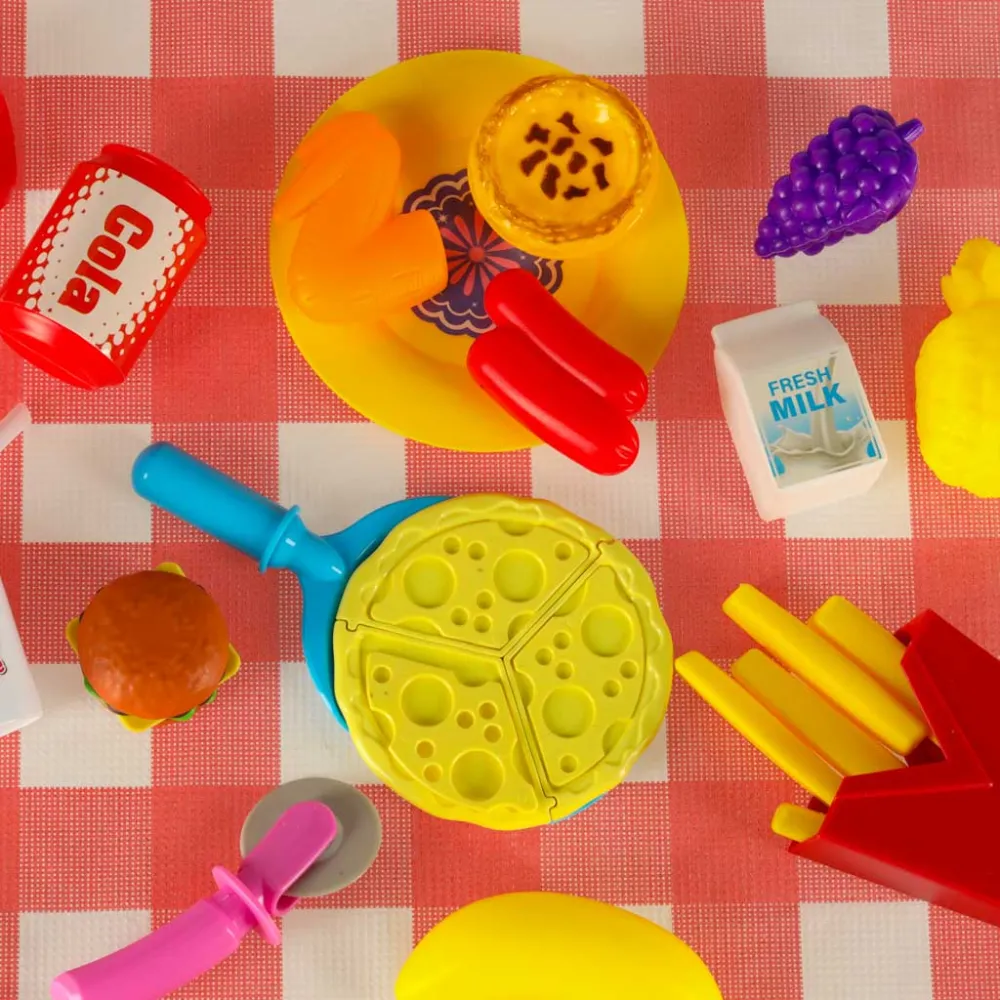 Zbliżenie na dziecięcy talerzyk z zabawkowym jedzeniem i naklejkami